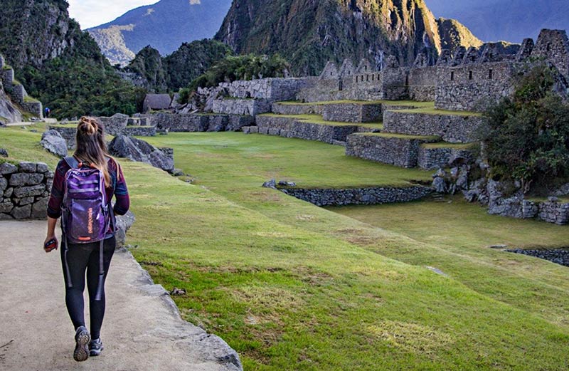 Turista visitando o sítio arqueológico de Machu Picchu
