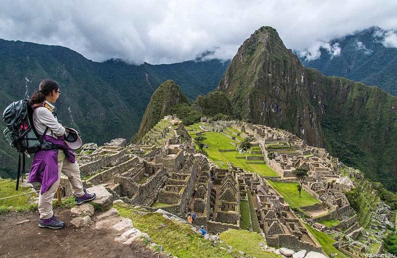 Turista observando a cidadela inca de Machu Picchu